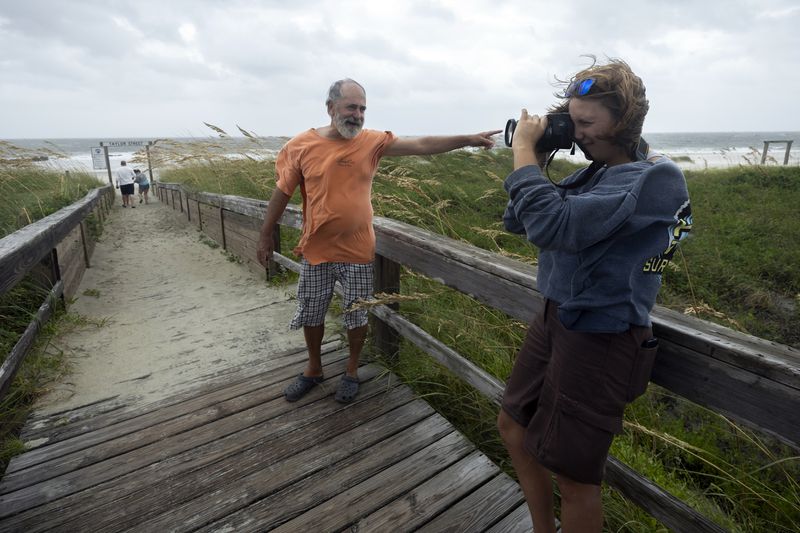 TYBEE ISLAND, GA - AUGUST 30, 2023: 
Abby Bentley, right, and her father Jim Bentley visit the north beach of Tybee Island to see the effects of Hurricane Idalia along the coast, Wednesday, Aug. 30, 2023, in Tybee Island, Ga. The storm made landfall Wednesday in Florida as a Category 3 before sweeping into Georgia. (AJC Photo/Stephen B. Morton)