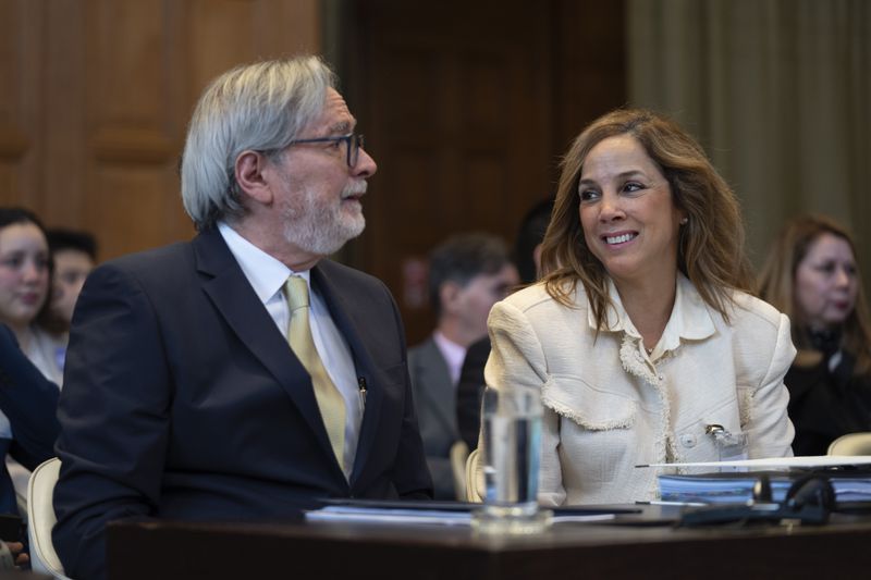 Ecuador's ambassador Andres Teran Parral, left, and agent Ana Maria Larrea, right, wait for judges to enter the International Court of Justice, or World Court, in The Hague, Netherlands, Wednesday, May 1, 2024. Mexico is taking Ecuador to the United Nations' top court on Tuesday accusing the nation of violating international law by storming into the Mexican embassy in Quito on April 5, and arresting former Ecuador Vice President Jorge Glas, who had been holed up there seeking asylum in Mexico. (AP Photo/Peter Dejong)