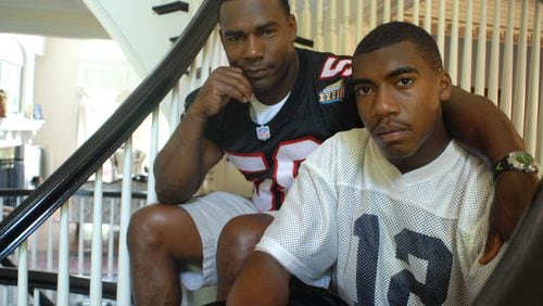Former Falcons linebacker Jessie Tuggle (left) with his son Justin Tuggle, when Justin was a senior and quarterback at Northview High School. Justin Tuggle now plays with the Houston Texans. (RENEE BROCK/AJC file)