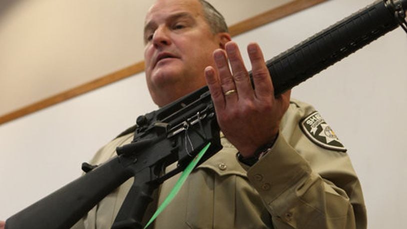 Former Cherokee County Sheriff Roger Garrison, displaying an AR-15 taken from a suspect's home. (Bob Andres/bob.andres@ajc.com)