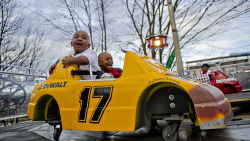 Kenneth Royal (left) and his brother Anthony hold on as they take a corner in a race car on one of the numerous rides at the Atlanta Fair on Wednesday, March 4, 2015. The fair runs through April 5. JONATHAN PHILLIPS / SPECIAL