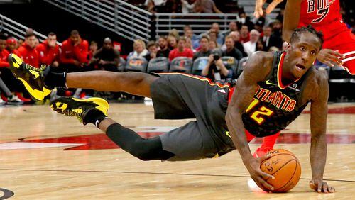 Atlanta Hawks forward Taurean Prince (12) dives for the ball as Chicago Bulls guard Justin Holiday (7) watches during the first half of an NBA basketball game Thursday, Oct. 26, 2017, in Chicago. (AP Photo/Charles Rex Arbogast)