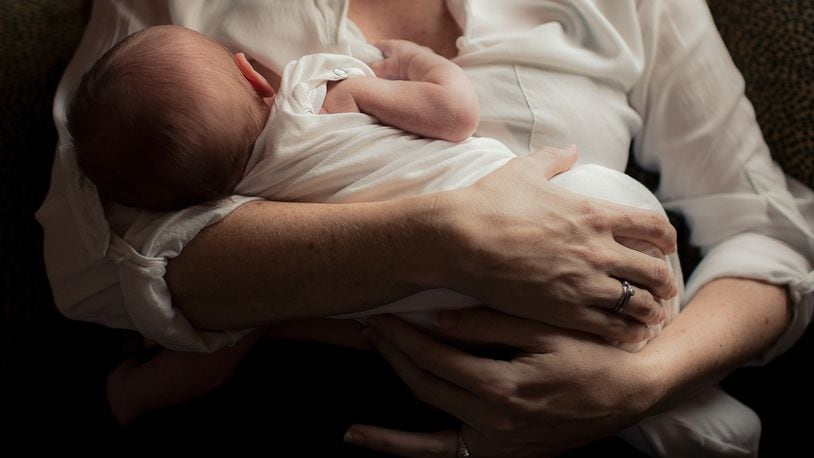 Mother holding newborn baby in arms (stock photo)