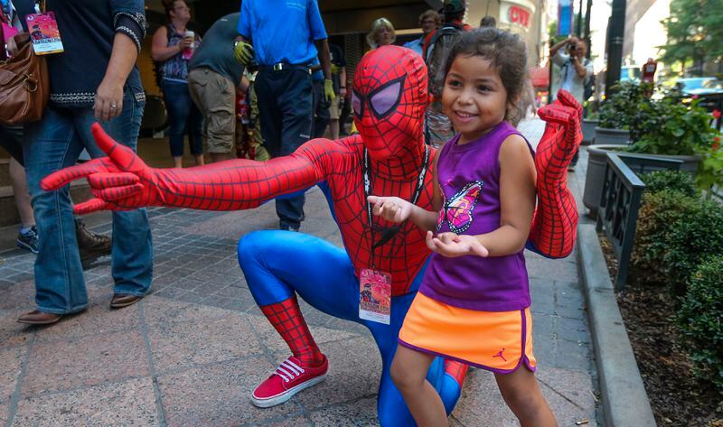 Dragon Con is always visually loaded. It can be monotonous though - with most of the photos being a rolodex parade of portraits. I liked this little fan interacting with Spiderman. She was genuinely thrilled to pose for her Mother to get a photo of her with Spidy. LEDE PHOTO - September 4, 2015 Atlanta: Terrance Ferguson (Spiderman) from Auburn, Alabama attending his third Dragon Con in Atlanta posed for a picture with Sofia Zamora-5 from Miami whose parents, Sara and Raff Zamora (not pictured) were photographing the pair on Peachtree Street downtown on Friday, Sept. 4, 2015. The four-day Dragon Con sci-fi, fantasy and comic book festival started Friday, taking over several downtown hotels. One of the highlights of the event is the 14th annual Dragon Con Parade, which marches down Peachtree Street beginning at 10 a.m. Saturday. Peter Mayhew, the 7-foot-2 actor who portrays Han Solo's furry co-pilot, Chewbacca in Star Wars will appear at Dragon Con this year. Channel 2 meteorologist Karen Minton said. "It's cloudy, drizzly, rainy all the way through our holiday weekend," she said. Minton put Atlanta's rain chance 60 percent Saturday and 40 percent Sunday and Monday. Highs will be in the low 80s Saturday and Sunday and mid-80s Monday. Overnight lows will be in the upper 60s to low 70s through the same period. JOHN SPINK / JSPINK@AJC.COM