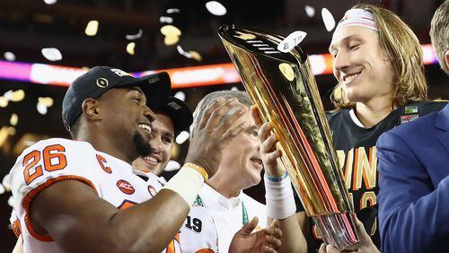 Adam Choice #26 and Trevor Lawrence #16 of the Clemson Tigers celebrate with the trophy after their teams 44-16 win over the Alabama Crimson Tide in the CFP National Championship presented by AT&T at Levi's Stadium on January 7, 2019 in Santa Clara, California.  (Photo by Ezra Shaw/Getty Images)