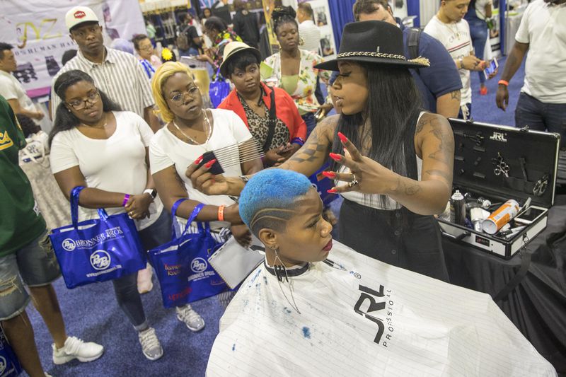 Brandi LaShay explains a technique while styling a model's hair during the Bronner Bros. International Beauty Show at the Georgia World Congress Center in Atlanta, Sunday, August 5, 2018.  (Photo: ALYSSA POINTER/ALYSSA.POINTER@AJC.COM)