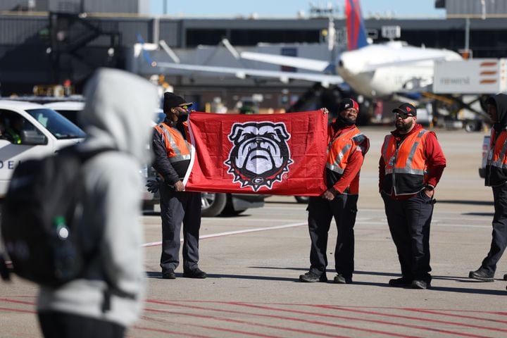 Hartsfield-Jackson Atlanta International Airport  crew members welcome the Georgia Bulldogs with a flag as the team arrives in Atlanta after winning the College Football Playoff National Championship, beating 33-18 to the Alabama Crimson Tide on Tuesday, January 11, 2022. Miguel Martinez for The Atlanta Journal-Constitution