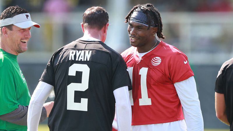 Atlanta Falcons wide receiver Julio Jones gives Matt Ryan a chest bump with quarterbacks coach Greg Knapp looking on the opening day of training camp on Friday, July 27, 2018, in Flowery Branch.