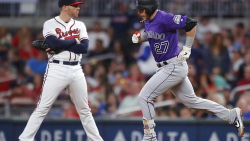 Trevor Story of the Colorado Rockies rounds first after hitting a three run home run as Freddie Freeman #5 of the Atlanta Braves reacts in the ninth inning. (Photo by Todd Kirkland/Getty Images)