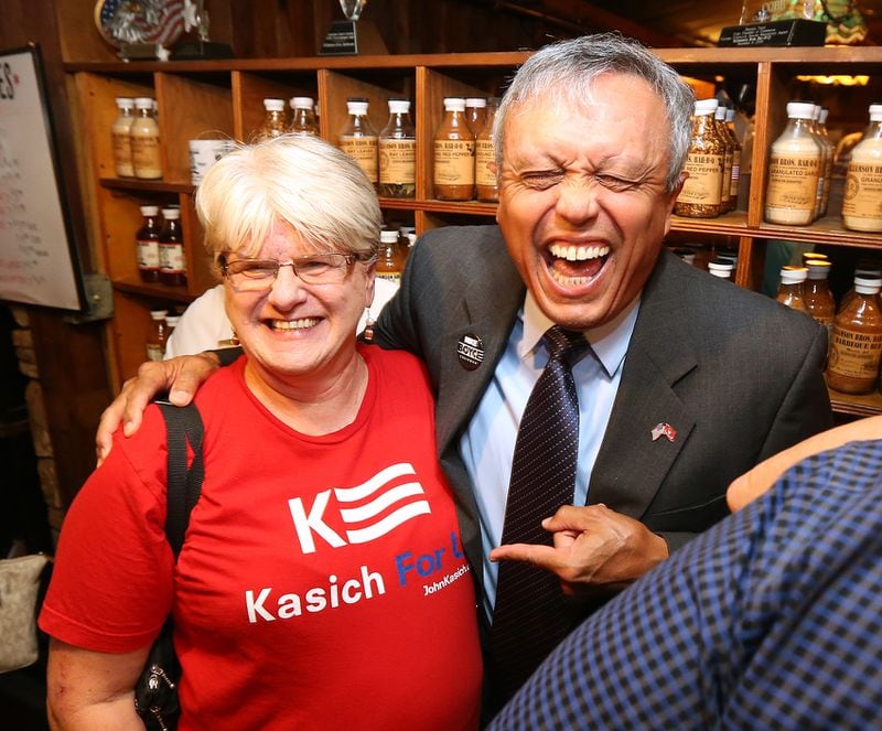 Mike Boyce shares a laugh with supporter Nancy Naidu over her shirt during his watch party at Williams Brothers BBQ on his way to winning the Cobb county commission Chairman's race in Marietta. (Curtis Compton /ccompton@ajc.com)