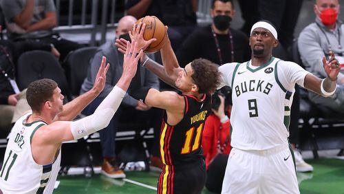 062521 Milwaukee: Milwaukee Bucks defender Brook Lopez, left, forces a turnover by Atlanta Hawks guard Trae Young with help from Bobby Portis during the 2nd quarter of game 2 in the NBA Eastern Conference Finals on Friday, June 25, 2021, in Milwaukee.   “Curtis Compton / Curtis.Compton@ajc.com”