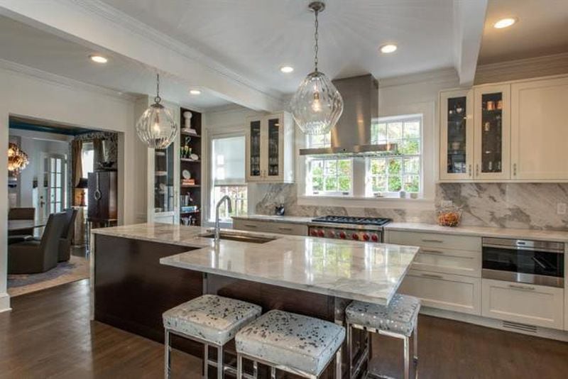 The stone countertops and white cabinets help to brighten the kitchen.