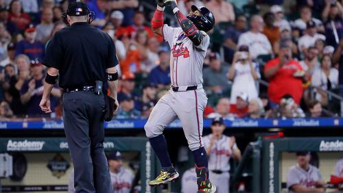 Atlanta Braves' Ronald Acuna Jr., right, celebrates his home run as he runs past home plate umpire Dan Bellino, left, during the fifth inning of a baseball game against the Houston Astros, Wednesday, April 17, 2024, in Houston. The Braves won 5-4 in 10 innings. (AP Photo/Michael Wyke)