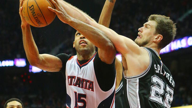 Center-power forward Tiago Splitter, shown here with San Antonio defending Hawks center Al Horford this past season, is now a Hawk after Wednesday's trade. (Curtis Compton/ccompton@ajc.com)