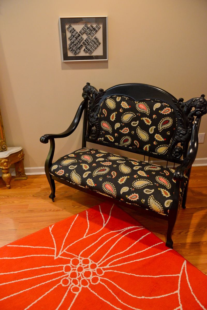 This 1880s settee with carved griffins, found on a "hunting" trip at a local Goodwill, was recovered with a paisley fabric and paired with a bright rug in the basement bedroom. Text by Lori Johnston and Keith Still/Fast Copy News Service. (Christopher Oquendo Photography/www.ophotography.com)