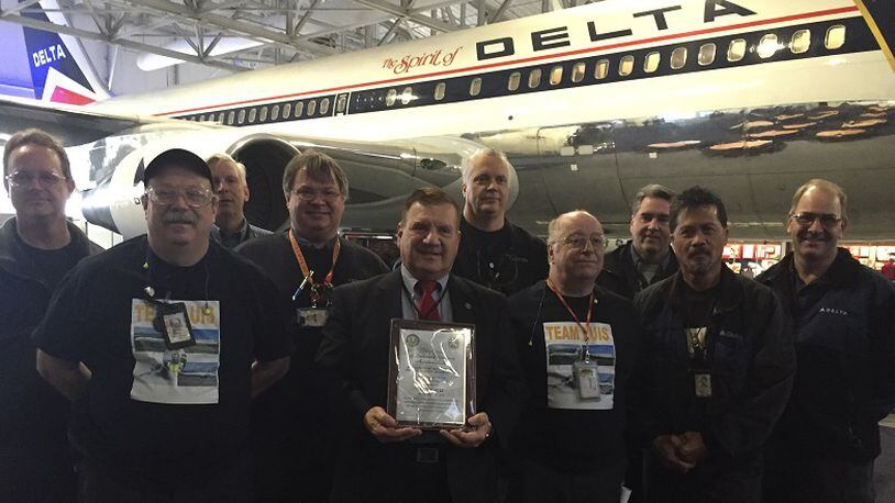 Luis Diaz of Marietta, center with plaque, received a prestigious lifetime achievement award for mechanics from the Federal Aviation Administration on Thursday. He posed with his former Delta Air Lines colleagues after the ceremony at the Delta Flight Museum. JEREMY REDMON/jredmon@ajc.com