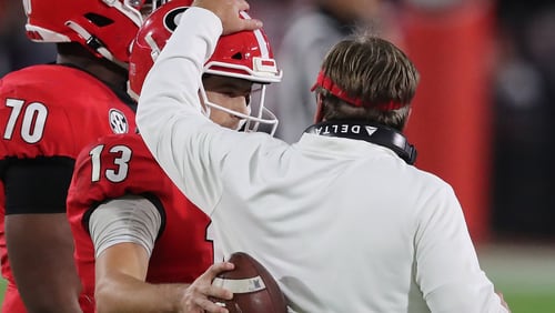 Georgia coach Kirby Smart gives QB Stetson Bennett a pat on the helmet during a moment on the sideline.