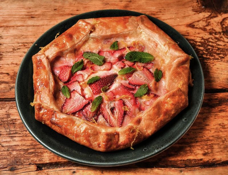 For this sweet galette by Two Urban Licks executive chef Shain Wancio, strawberries are placed on top of sweetened cream cheese on a piece of pie crust. (Styling by chef Shain Wancio / Chris Hunt for the AJC)