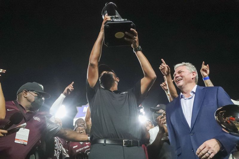 08/28/2021 — Atlanta, Georgia — In 2018, John Grant, CEO of the Cricket Celebration Bowl, added an early season game - the Cricket MEAC-SWAC Challenge - to the portfolio to kick off the college football season. Here, North Carolina Central Eagles head coach Trei Oliver raises the Cricket MEAC/SWAC Challenge trophy after beating the Alcorn State Braves following a football game at Center Parc Stadium in Atlanta, Saturday, August 28, 2021. (Alyssa Pointer/Atlanta Journal-Constitution)