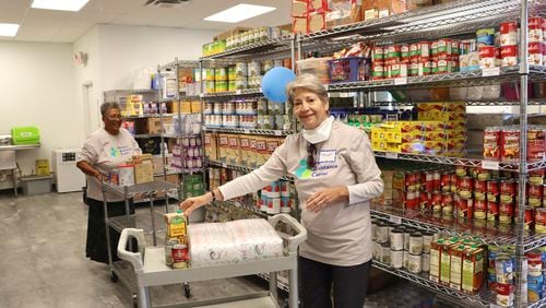 Janet Bernstein (right) and Freda Lewis restock the food pantry at the Midtown Assistance Center, which recently moved to new home on Spring Street.
