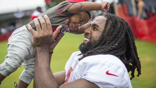 Tampa Bay Buccaneers defensive back J.J. Wilcox (27) holds son James Wilcox III, 7 months, after practice at training camp at One Buccaneer Place in Tampa, Fla., on Monday, July 31, 2017.  (Loren Elliott /Tampa Bay Times via AP)