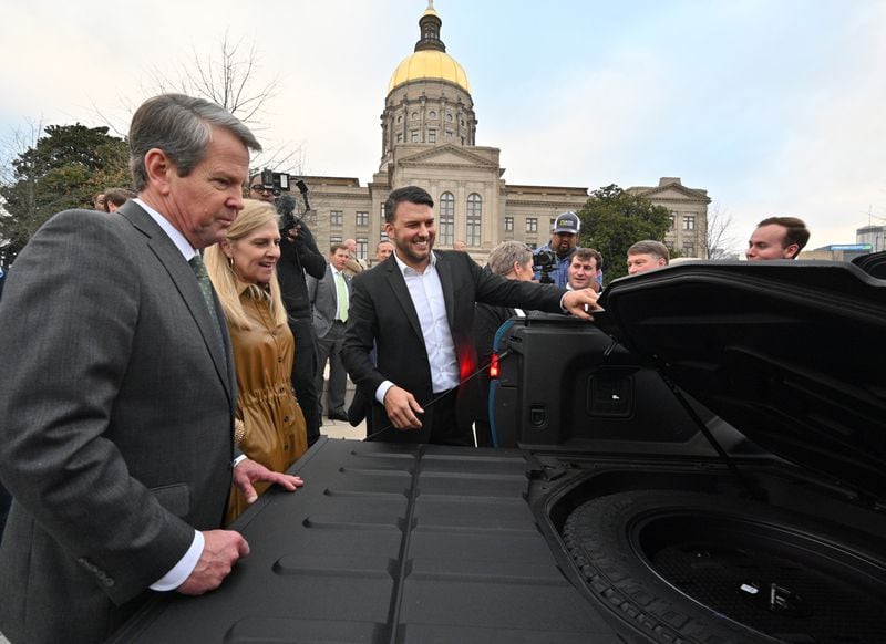 December 16, 2021 Atlanta - Jimmy Knauf EVP of Facilities at Rivian, smiles as he shows Rivian R1T electric truck to Georgia Governor Brian Kemp (left) and First Lady Marty Kemp (second from left) during a press conference at Liberty Plaza across from the Georgia State Capitol in Atlanta on Thursday, December 16, 2021.  (Hyosub Shin / Hyosub.Shin@ajc.com)