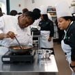 Zanaya Pullum stirs a sauce as Chef Mimi Bates, program director at the Navigate Foundation looks on during a guided cooking lesson on Tuesday, May 7, 2024. Through the program, students from Atlanta area schools get hands-on training in the field and culinary internships. (Natrice Miller/ AJC)