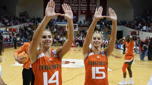 FILE - Miami's Haley Cavinder (14) and Hanna Cavinder (15) celebrate following a second-round college basketball game against Indiana in the women's NCAA Tournament Monday, March 20, 2023, in Bloomington, Ind. Haley Cavinder announced her return to Miami on Friday, April 18, 2024, one day after twin sister Hanna said she was going back to the Hurricanes. (AP Photo/Darron Cummings, File)
