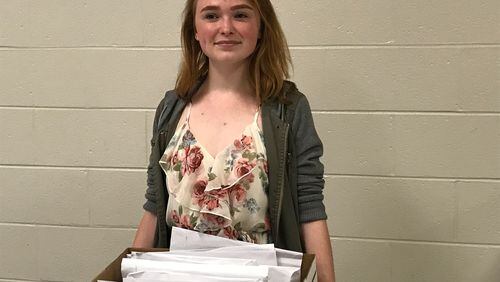 Megan Hawes, a senior at Gwinnett County's Brookwood High School, wrote cards and letters congratulating each member of the class of 2017. Hawes is standing behind envelopes with some of the notes. ERIC STIRGUS / ESTIRGUS@AJC.COM