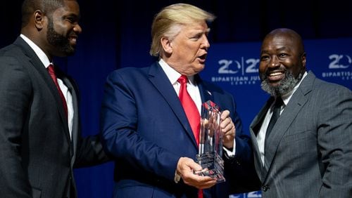 President Donald Trump is presented an award by Byron Donalds, left, and Matthew Charles, before addressing the 2019 Second Step Presidential Justice Forum at Benedict College in Columbia, S.C. on Friday, Oct. 25, 2019. (Erin Schaff/The New York Times)