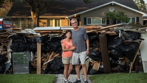 John Walton, 68, and Michele Walton, 61, outside of their flood-damaged home in Houston. Amid the storm devastation, some people in Texas found ways to save treasured personal items. (Tamir Kalifa/The New York Times)