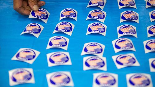 A poll worker lays out "I voted" stickers at Chesapeake Central Library on Nov. 8, 2022. (Kendall Warner/The Virginian-Pilot/TNS)
