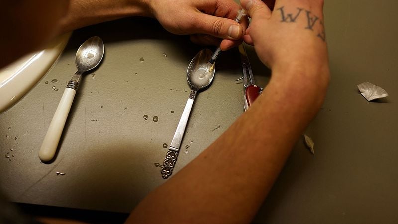 Drugs are prepared to shoot intravenously by a user addicted to heroin. (Photo by Spencer Platt/Getty Images)