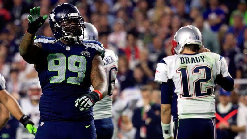 Tom Brady walks off as Tony McDaniel of the Seattle Seahawks celebrates stopping the New England Patriots on third down in Super Bowl XLIX in 2015. New England won the game.