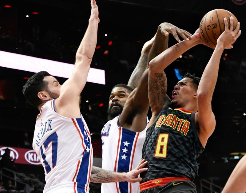 Hawks guard Damion Lee (8) shoots as Philadelphia 76ers guard JJ Redick (17) and center Amir Johnson defend during the first half of an NBA basketball game Tuesday, April 10, 2018, in Atlanta. (AP Photo/John Amis)