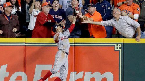 Fans interfere with Boston Red Sox right fielder Mookie Betts trying to catch a ball hit by Houston Astros' Jose Altuve on Wednesday, Oct. 17, 2018, in Houston.