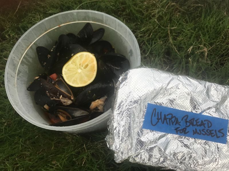 Packaged in a plastic container with grilled bread wrapped in foil, Two Urban Licks' steamed mussels are takeout-ready. Ligaya Figueras / ligaya.figueras@ajc.com
