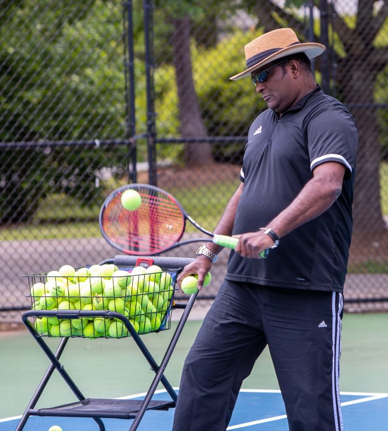 Tennis instructor Francis Ali works with his daughter Brianna during a session at the Lucky Shoals Park tennis courts in Norcross. Phil Skinner/For The Atlanta Journal-Constitution