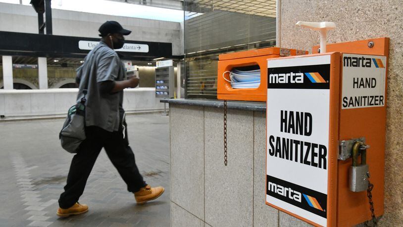 March 25, 2021 Atlanta - A Marta customer walks past mask and hand sanitizer dispensers at the Five Points MARTA station on Thursday, March 25, 2021. MARTA stepped up cleaning of buses and other facilities during the COVID-19 pandemic. It also stopped collecting bus fares for months to limit contact between passengers and drivers, and it saw sales taxes — another key source of revenue — fall. But federal coronavirus recovery aid has helped shore up operations at MARTA and other transit agencies in the region.  (Hyosub Shin / Hyosub.Shin@ajc.com)