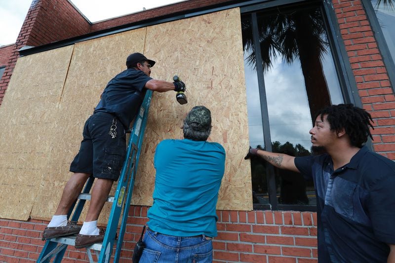 Employees Ricardo Bivvens (from left), Frank Braun and Arthur Knight board up the windows Monday at the Cumberland Inn & Suites in St. Marys  in preparation for Hurricane Dorian. Mandatory evacuation has been issued for the area east of Interstate 95. (Photo: Curtis Compton/ccompton@ajc.com)