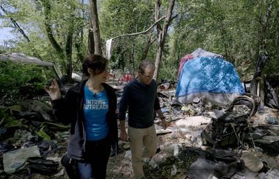 Tracy Woodard, a team leader for non-profit Intown Cares, walks with AJC reporter Matt Kempner  in the homeless encampment where Gerard Alexander would live. (Ryon Horne / Ryon.Horne@AJC.com)