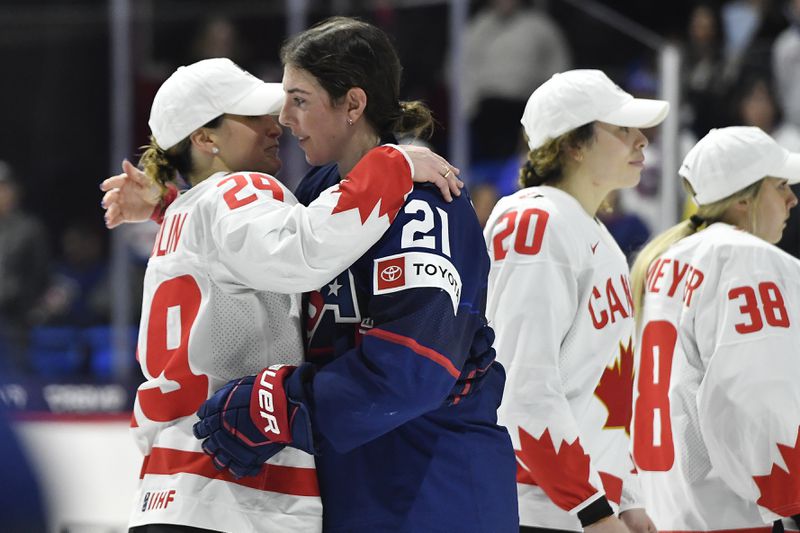 United States forward Hilary Knight, right, hugs Canada forward Marie-Philip Poulin after Canada won the final at the IIHF Women's World Hockey Championships in Utica, N.Y., Sunday, April 14, 2024. (AP Photo/Adrian Kraus)