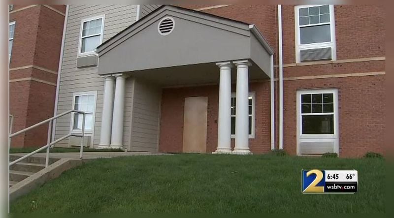 A dorm door is boarded up after two shots were fired through it at Reindhardt University, officials said. (Credit: Channel 2 Action News