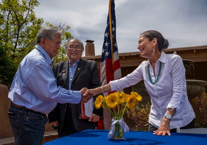 Interior Secretary Deb Haaland shakes hands with Gov. Myron Armijo of Santa Ana Pueblo after signing Public Land Order 7940, which protects more than 4,200 acres of Bureau of Land Management-managed public lands that is sacred to Tribes in the Placitas area, during a community event at El Zócalo Plaza in Bernalillo, N.M., Thursday, April 18, 2024. For the next 50 years, the lands will be closed to new mining claims, mineral sales, and oil and gas leases.(Chancey Bush/The Albuquerque Journal via AP)