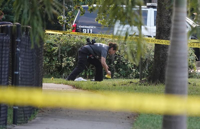 A Hollywood Police Department crime scene investigator places markers at the scene where Officer Yandy Chirino was killed in Hollywood, Florida on Oct. 18. (Joe Cavaretta/South Florida Sun Sentinel/TNS)