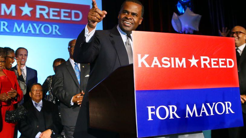 Atlanta Mayor Kasim Reed thanks supporters for four more years with ambassador Andy Young (seated) looking on while delivering his victory speech at his election night celebration on Nov. 5, 2013, in Atlanta.