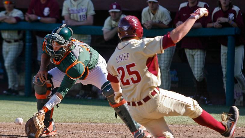 Miami catcher Garrett Kennedy, left, cannot hold on to the throw as Florida State's Brett Knief (25) scores in the sixth inning of an NCAA college�baseball�game on Sunday, March 2, 2014, in Tallahassee, Fla. Florida State won 13-6. (AP Photo/Phil Sears)