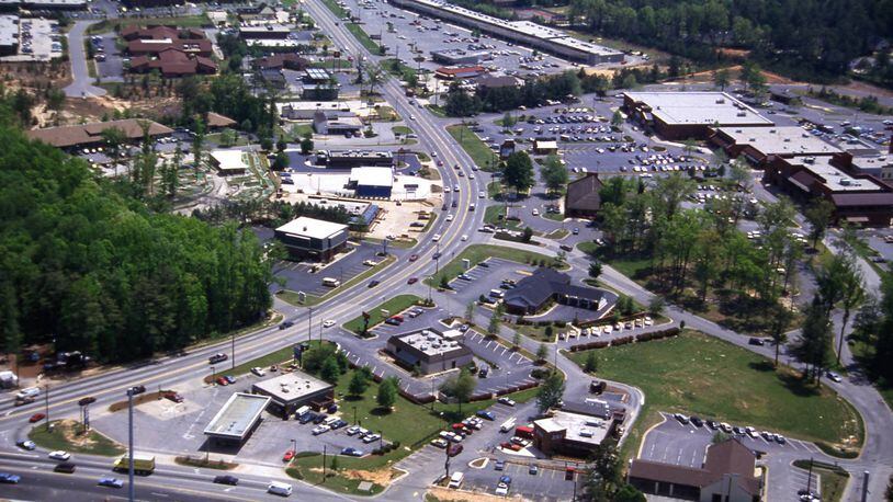 Aerial view of businesses along Johnson Ferry Road, looking southeast, Cobb County, Georgia, April 21, 1988. his has the intersection with GA 120 (Upper Roswell Rd) in foreground looking SE along JF. Merchants Walk is on the right side of the street." Photographer: Calvin Cruce.