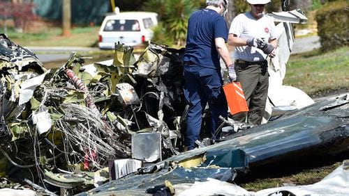 Officials with the National Transportation Safety Board and FAA remove a black box from the crashed Cessna Citation I on Saturday in Cobb County. (Credit: The Associated Press)