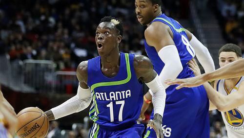 Atlanta Hawks' Dennis Schroder (left) dribbles past a screen set by teammate Dwight Howard in the second quarter Monday against the Golden State Warriors in Atlanta.